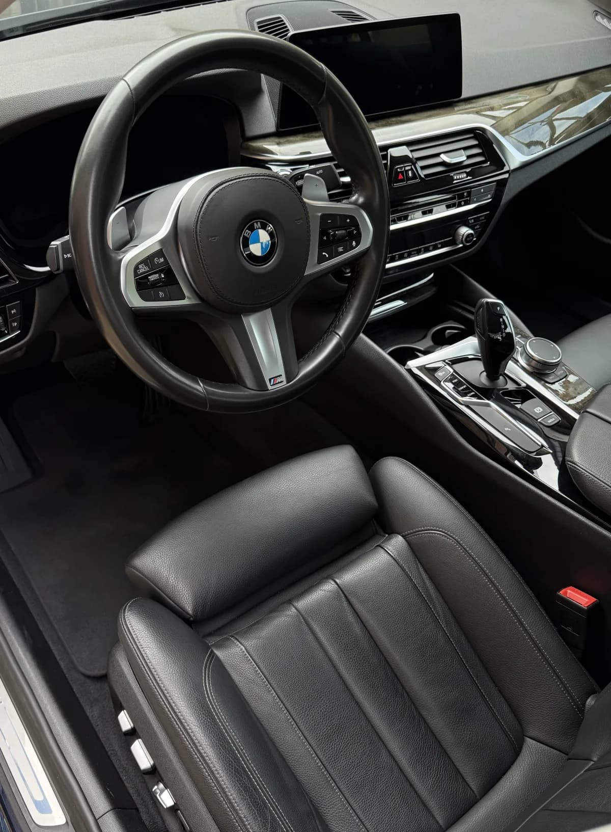 Gereinigter BMW-Innenraum mit Lenkrad, Ledersitz und Mittelkonsole